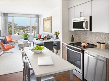 a kitchen and living room with a table and chairs